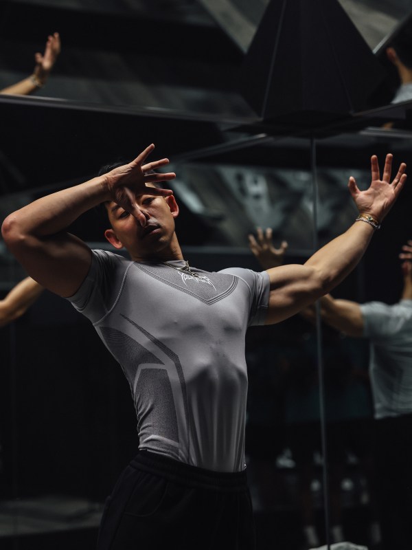 Kevin Shen mid-set, reflected in the mirrors of a low-lit gym