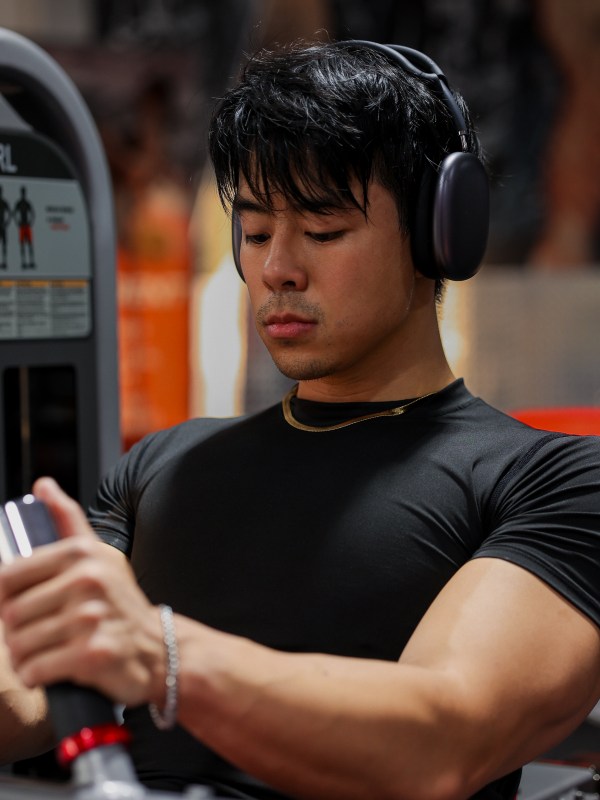 Close-up between sets, headphones on, checking a training timer