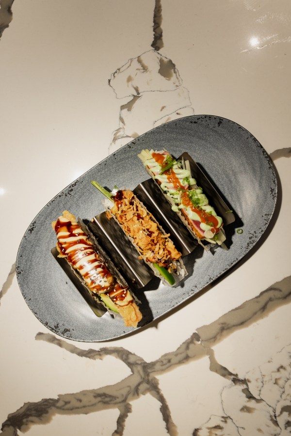Hand rolls plated on a speckled ceramic dish at Okane Sushi